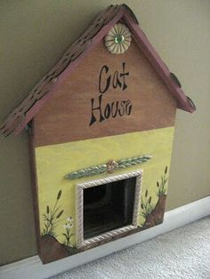 a dog house that is painted yellow and brown with the words'cat house'written on it