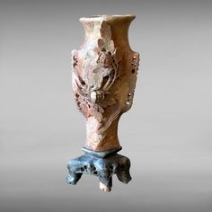 an old vase is sitting on a stand