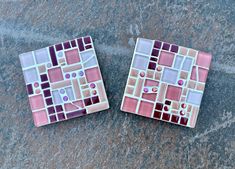 two pink and purple mosaic tiles sitting on top of a stone floor next to each other