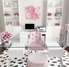 a white and pink home office with flowers on the wall behind the glass desk, along with black and white rugs