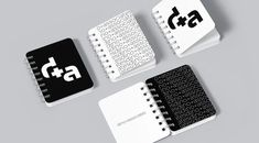 three spiral notebooks with black and white designs