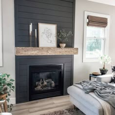 a living room with a fire place in the center and a couch on the other side