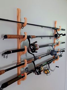 there are many fishing rods and reels hanging on the wall