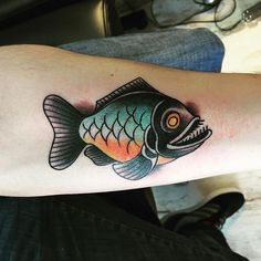 a man's arm with a fish tattoo on it