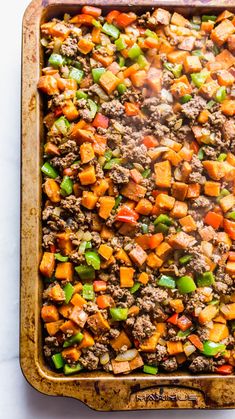 a casserole dish filled with ground beef and vegetables