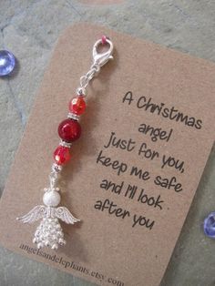 a christmas angel keychain with red and white beads on it's side