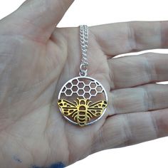 Here is our beautiful Bee and Honeycomb Necklace, a lovely mix of classic style and beauty inspired by nature. With great care and attention to detail, this necklace has a round silver-plated honeycomb charm and a shiny gold-plated bee that go perfectly together. The difference is stunning and is sure to get people's attention. Honeycomb Necklace, Leather Charm Bracelets, Lotus Jewelry, Celtic Jewelry, Affordable Jewelry, Inspired By Nature, Glass Necklace, Honeycomb, Charm Jewelry