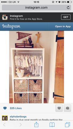 a baby's closet with clothes hanging on the shelves and baskets in front of it