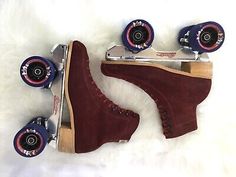 two skateboards with wheels and one has red suede boots on it, sitting on a white fur surface