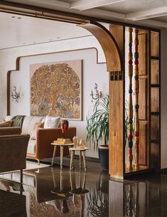 a living room filled with furniture and a painting on the wall next to a doorway