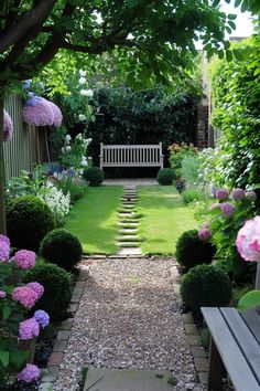 a garden with stone steps leading to a bench