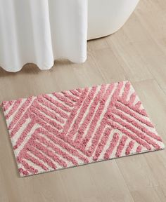 a pink and white bathroom rug on the floor