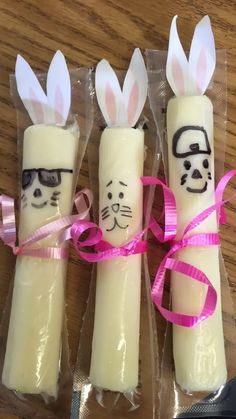 three candles with bunny ears and glasses on them, wrapped in cellophane wrappers