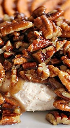 a white plate topped with chicken covered in pecans