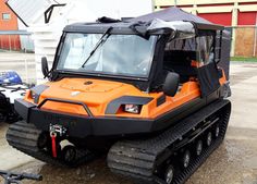 an orange and black vehicle parked in front of a building