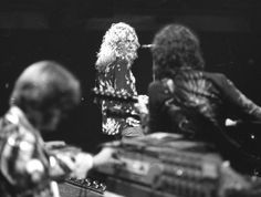 three people playing instruments in front of a keyboard