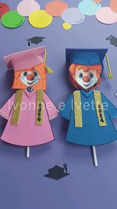 two paper dolls with graduation caps and gowns