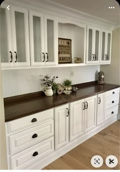 a kitchen with white cabinets and black counter tops