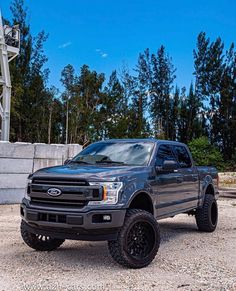 a black truck is parked in the gravel