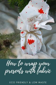 an ornament wrapped in white paper with red hearts on it and the words how to wrap your presents with fabric