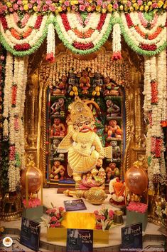 a shrine with flowers and decorations on the wall, including an idol in the center