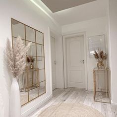 a white room with mirrors and vases on the floor