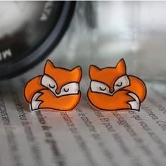 two little foxes are sitting next to each other on top of a piece of paper