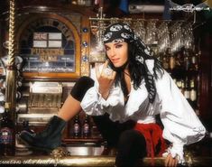 a woman in pirate garb sitting at a bar with her hand on her hip