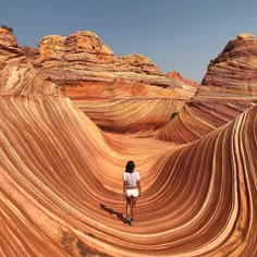 a person standing in the middle of an area that looks like wavy rocks and sand