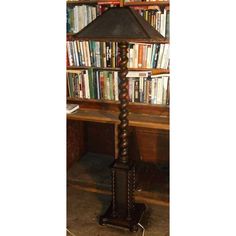 a lamp sitting on top of a wooden table in front of a book shelf filled with books