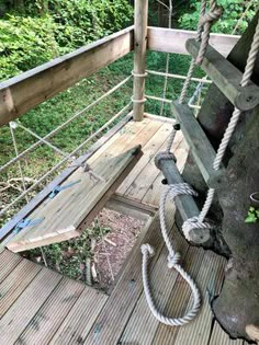 a wooden deck with ropes on it and some trees in the backgrouds