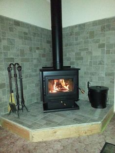 a wood burning stove sitting on top of a stone floor