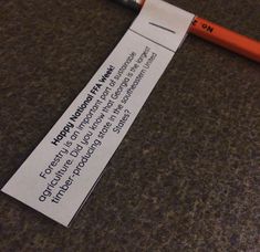 an orange pencil sitting on top of a piece of paper