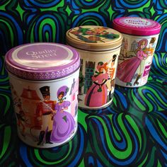 three tins with princesses on them sitting next to each other in front of a colorful background