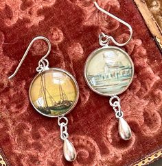 Antique postcard clippings, of a sailboat at sunset and a shack on a dock or wharf, sit under a glass dome in these lovely earrings.  The postcard dated back to the early 1900's.  These earrings are very lightweight, and measure 1.5" total.  The ear wires are sterling silver. I work with antique and vintage parts. Some may show signs of wear or age. Please look at each picture closely. I have tried to show all aspects of my work. Please contact me before purchasing if you have any questions or would like more clarity in a picture. I like to think that older items have a character that newer parts have not yet earned. Vintage Brass Clip-on Earrings As A Gift, Sea Lover, Antique Postcard, Glass Dome, Lovely Earrings, Earrings Vintage, Vintage Earrings, Ear Wires, Vintage Antiques