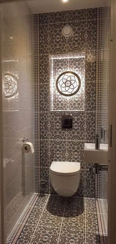 a bathroom with a toilet, sink and mirror in it's stall door area