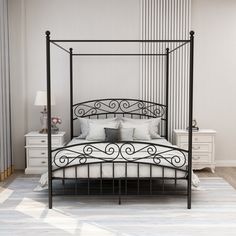 a black iron bed frame with white pillows