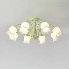 a green chandelier with white flowers hanging from it