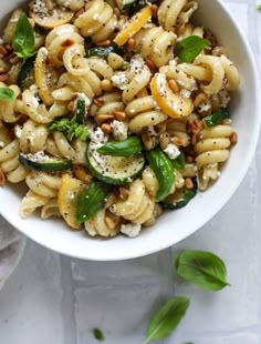 a white bowl filled with pasta and vegetables