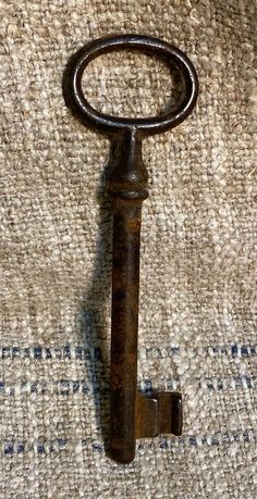 an old rusty key laying on top of a rug