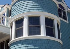 a blue house with white balconies and windows