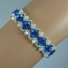 a close up of a bracelet on a person's arm with blue and white beads