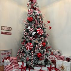 a christmas tree decorated with red and white candy canes, candies, and ornaments