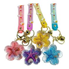 four different colored plastic key chains with bows and stars on them, all in various colors