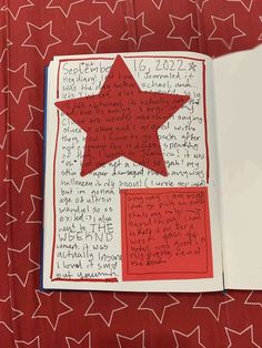 an open book with writing on it and a red star in the middle is shown