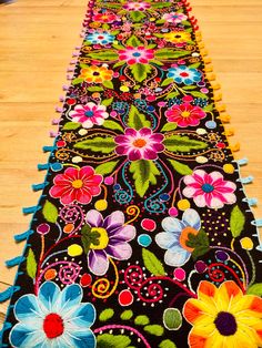 the long table runner is decorated with colorful flowers