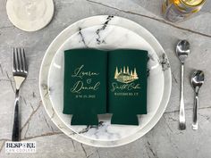 two green wedding napkins sitting on top of a white plate next to silverware