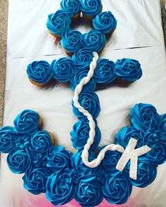 cupcakes with blue icing are arranged in the shape of an x