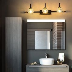 a bathroom with a sink, mirror and lights on the side of the wall in front of it