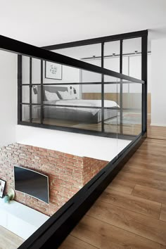 a bedroom with a brick fireplace and glass walls